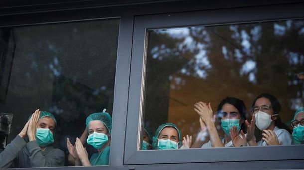 Varias sanitarias aplaudiendo por la ventana.