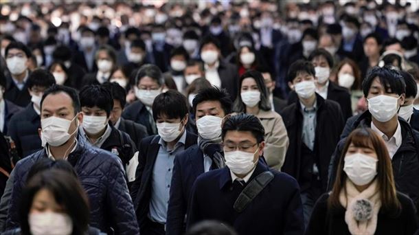 Japoneses caminan por la calle con mascarilla