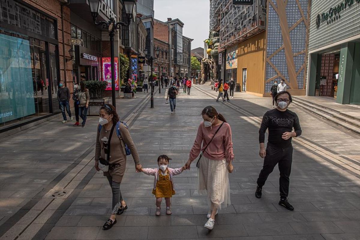 Varias personas salen a la calle con mascarillas en Wuhan (China)
