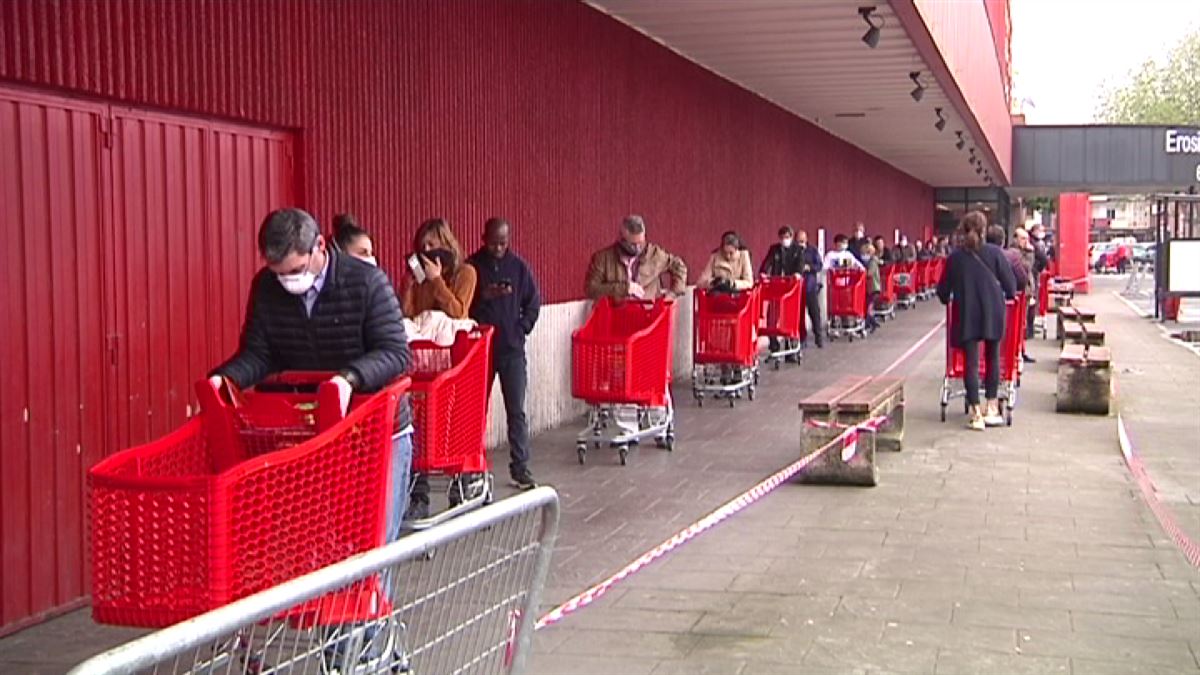 Larga cola para entrar a un supermercado.