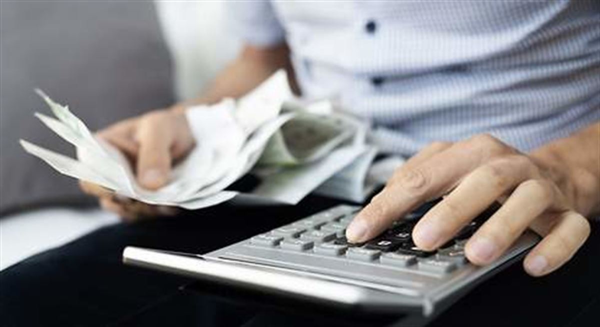 Imagen de archivo de una persona con facturas y una calculadora.
