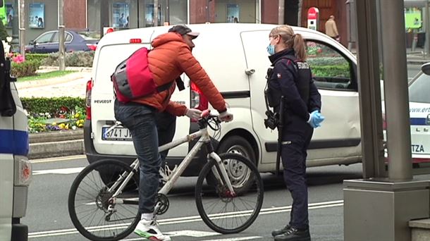 Una ertzaina hablando con un ciclista