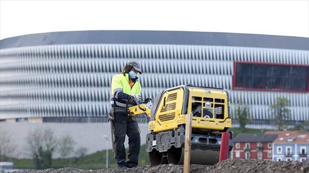 Una persona trabajando en Bilbao, con San Mamés al fondo.