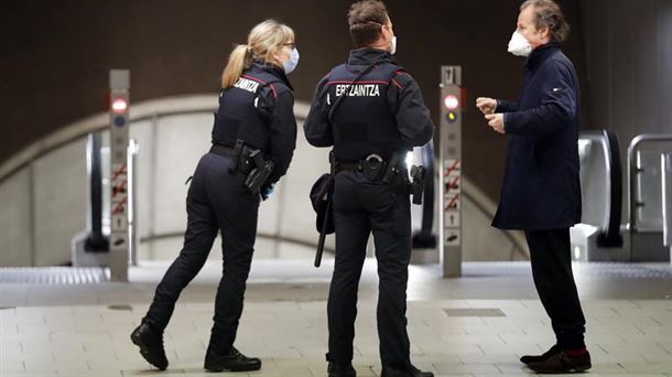 Dos ertzainas y un viajero con mascarillas en el metro de Bilbao.