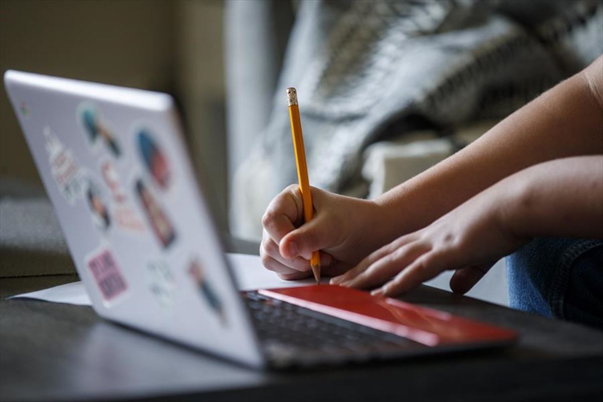 Un estudiante hace sus deberes con un ordenador portátil.