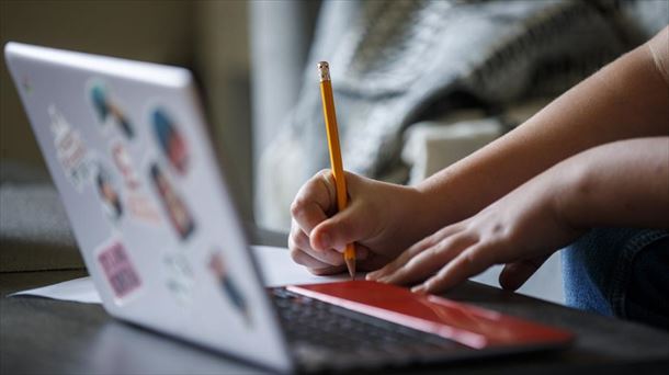 Un alumno realiza sus trabajos con el ordenador en casa. 