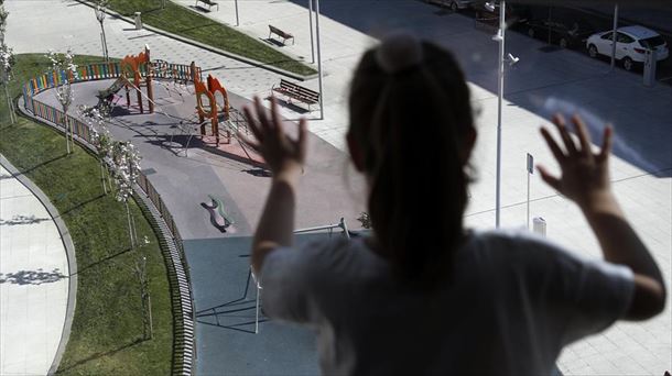 Una niña mira por la ventana durante el confinamiento.