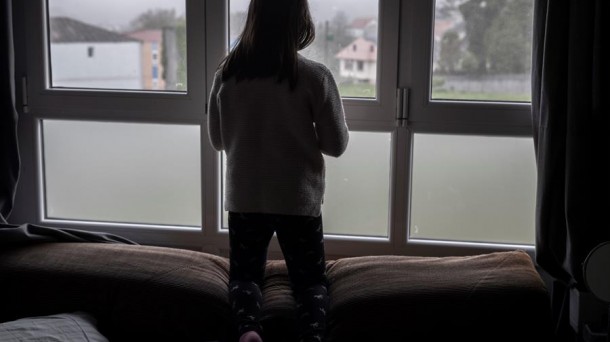 Una niña mira por la ventana durante el confinamiento domiciliario del año pasado.