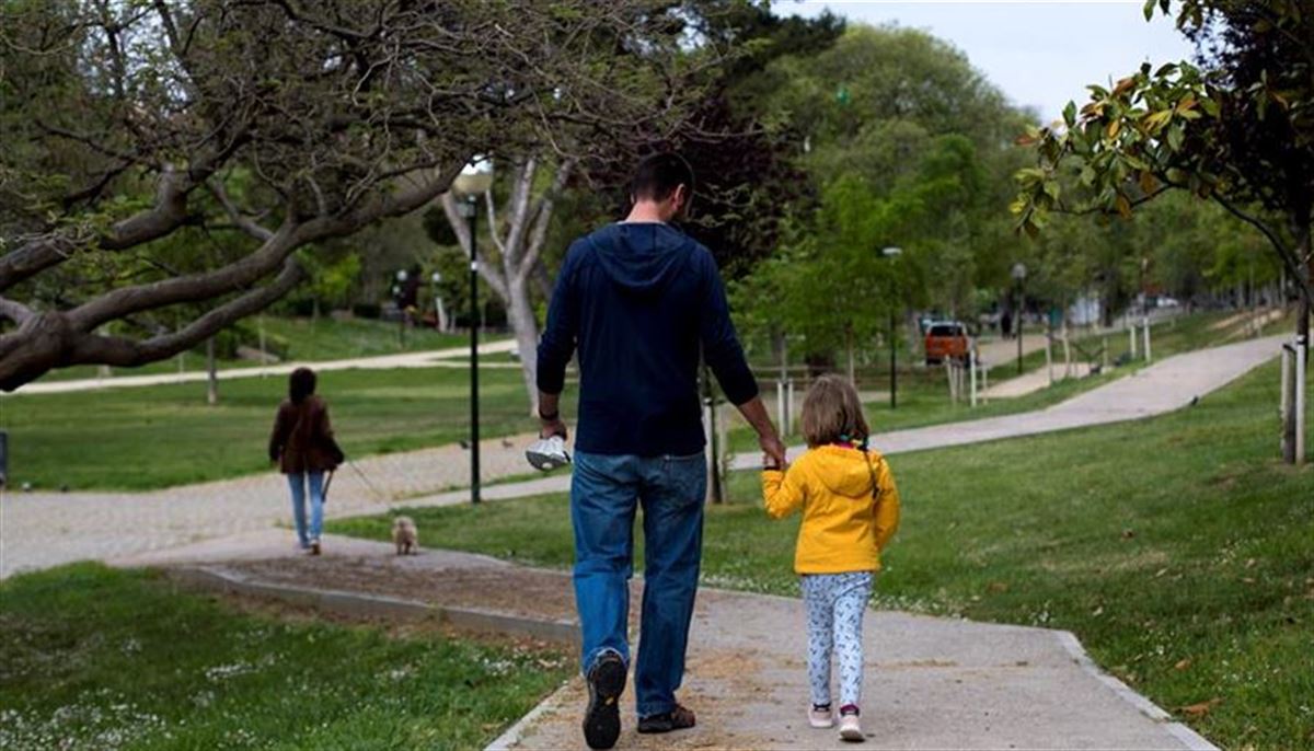 Una niña pasea con su padre por un parque. Foto de archivo: EFE