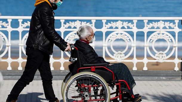 Una persona cuida de un anciano. Foto: Efe