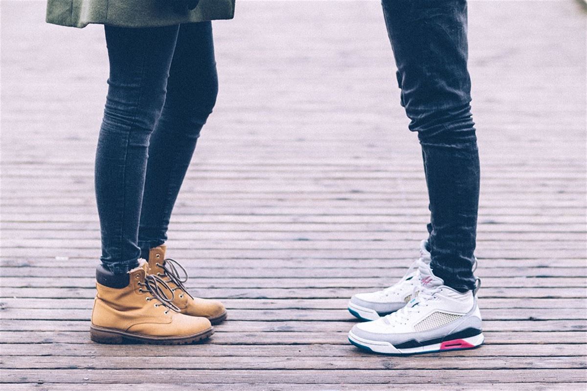 Dos personas vistiendo un par de botas y un par de zapatillas.