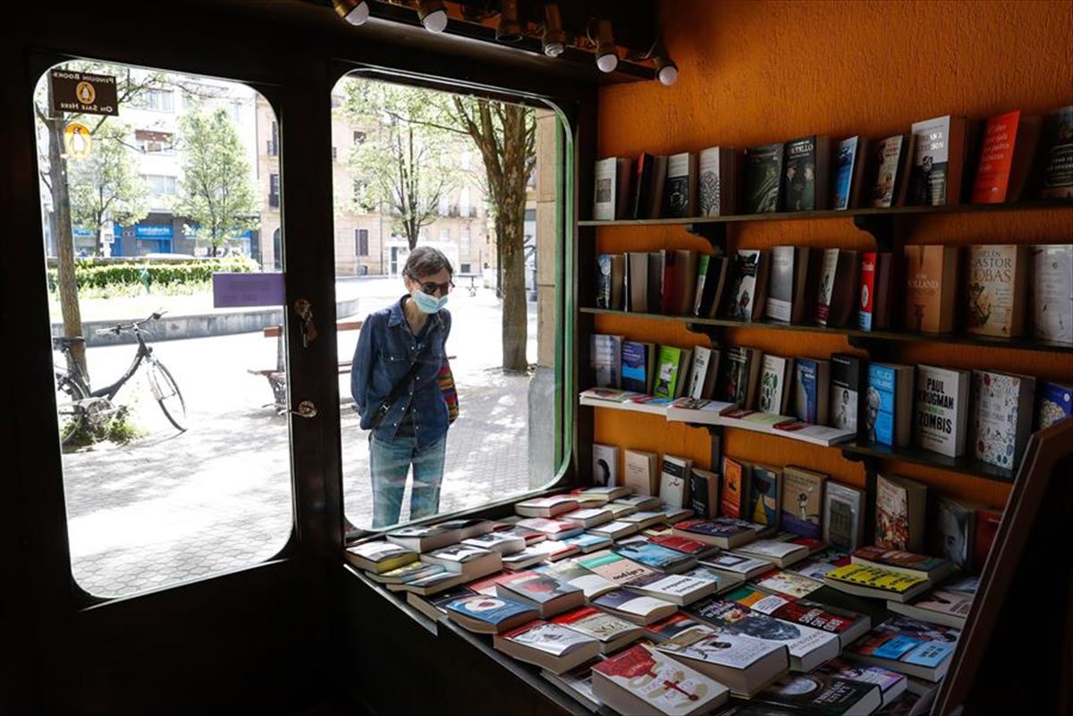 Una persona mira el escaparate de una librería cerrada en San Sebastián.