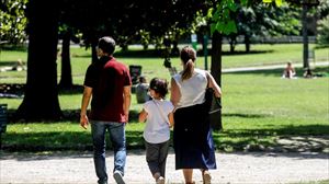 Un padre y una madre paseando con su hija. Foto: EFE