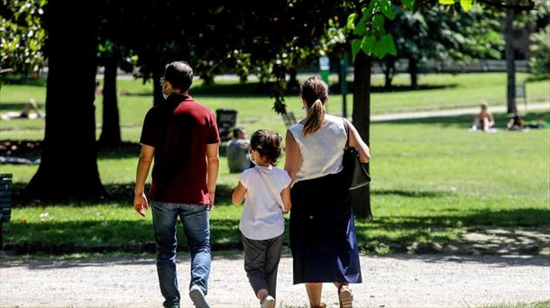 Un padre y una madre paseando con su hija