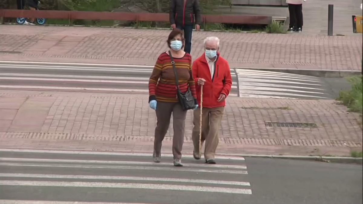 Dos adultos, paseando con mascarillas.