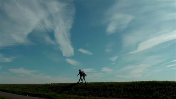 Dos personas caminando por un prado