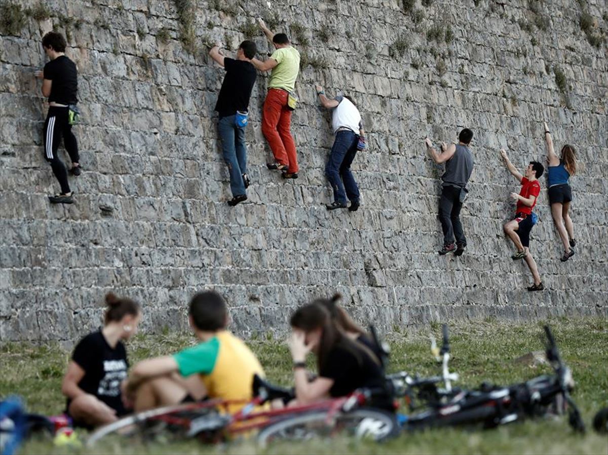 Un grupo de jóvenes practica escalada en las murallas de la ciudadela de Pamplona.