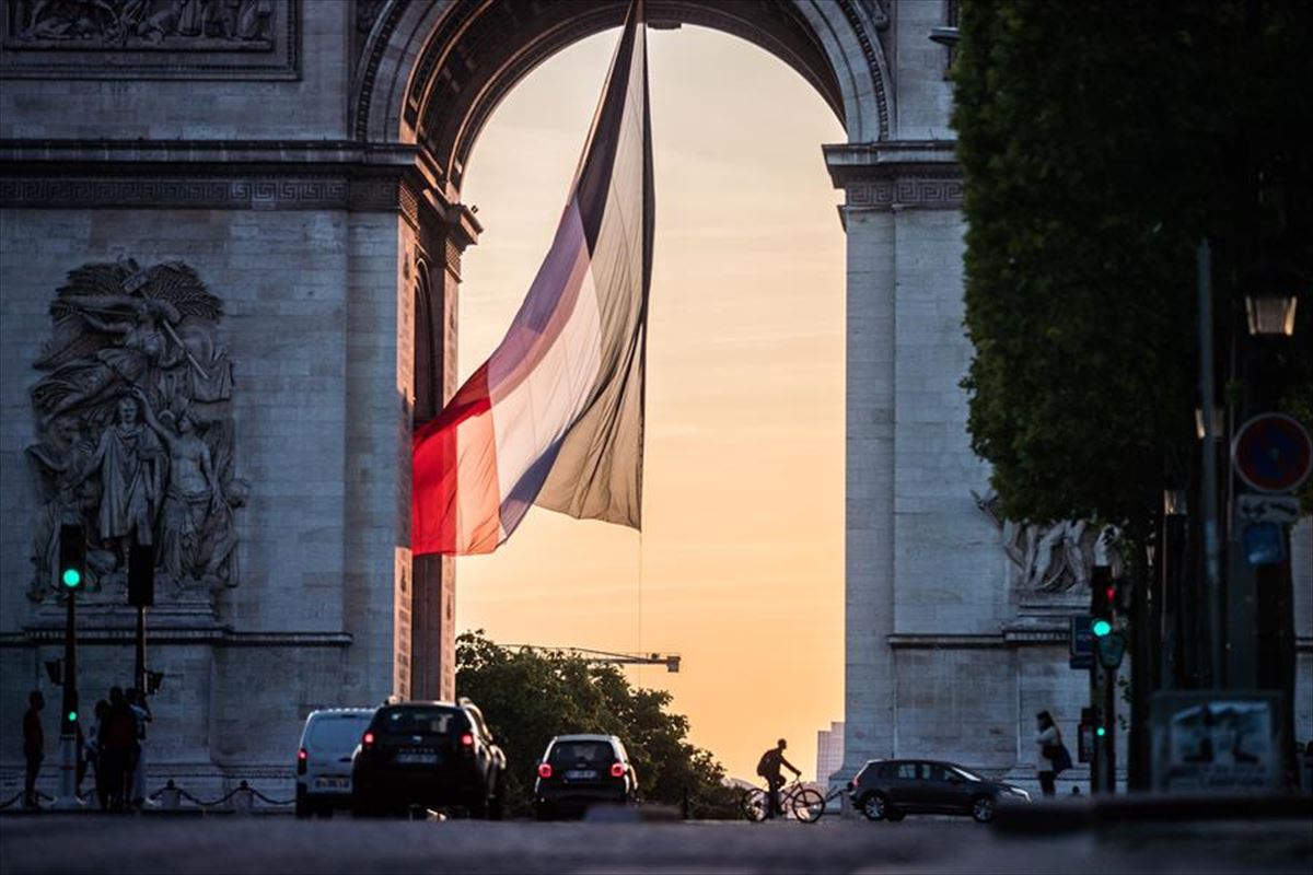 El Arco del Triunfo de París y una gran bandera francesa