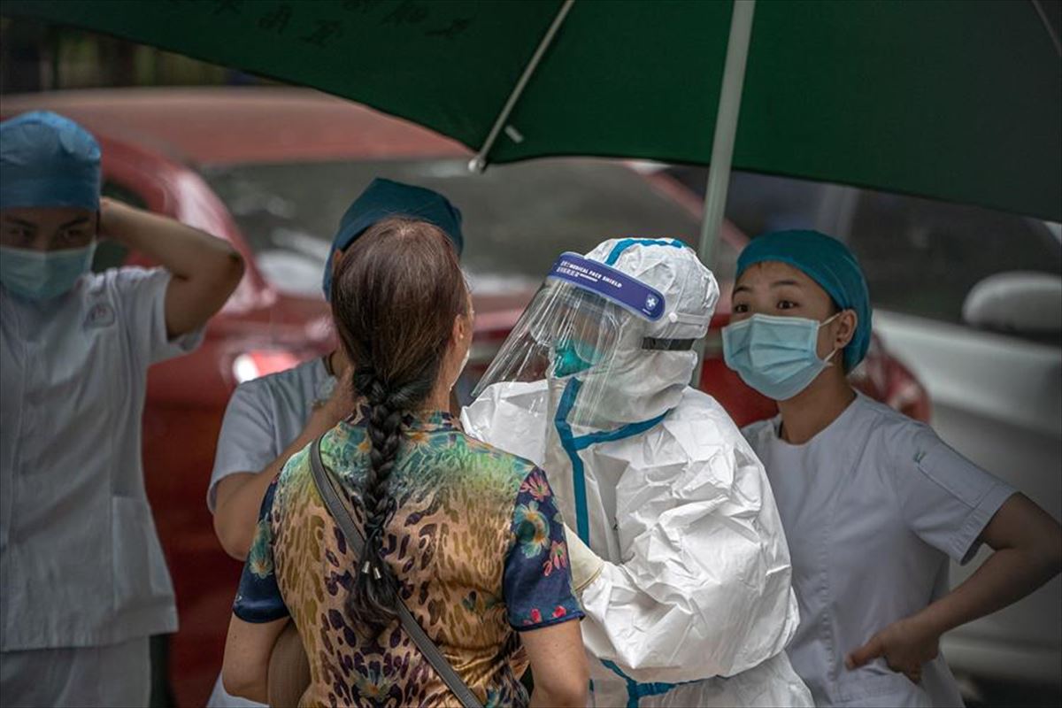 Personal sanitario realiza un test de COVID-19 a una mujer en Pekín