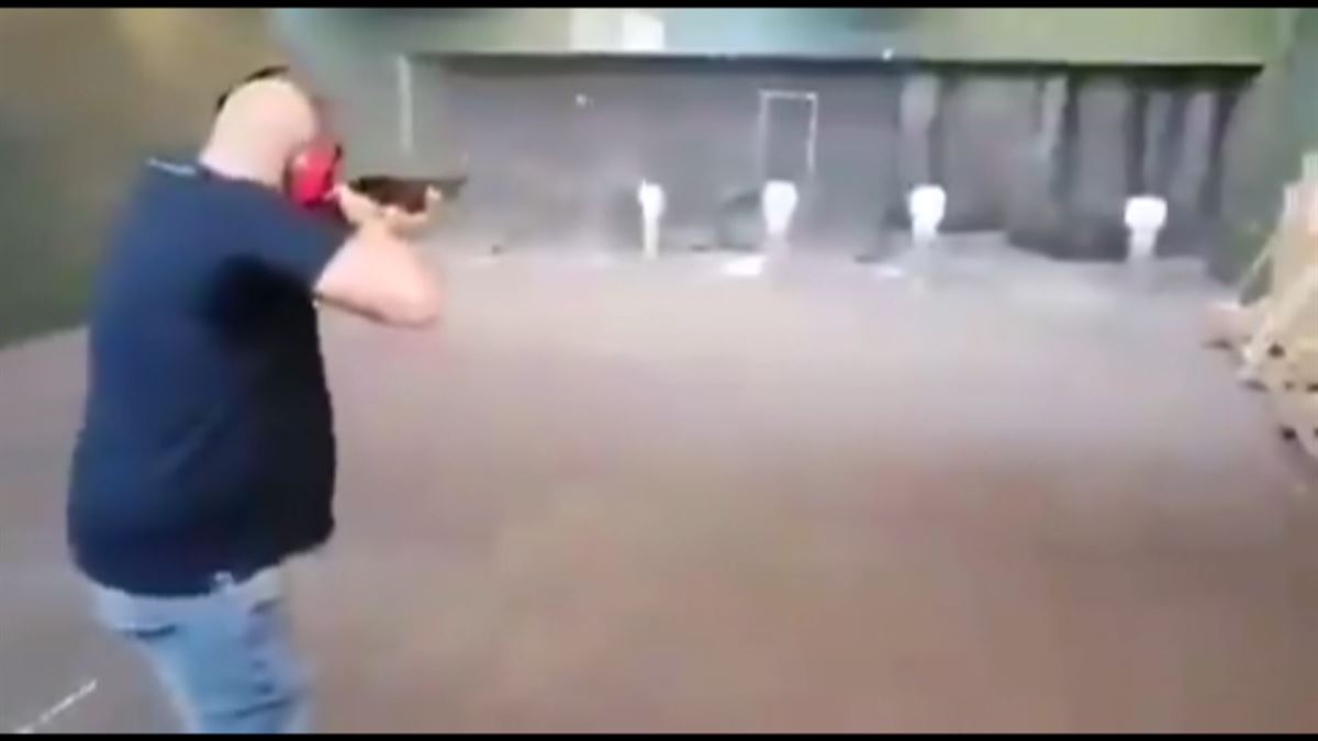 Hombre disparando a fotos de miembros del Gobierno español. Foto obtenida de un vídeo.