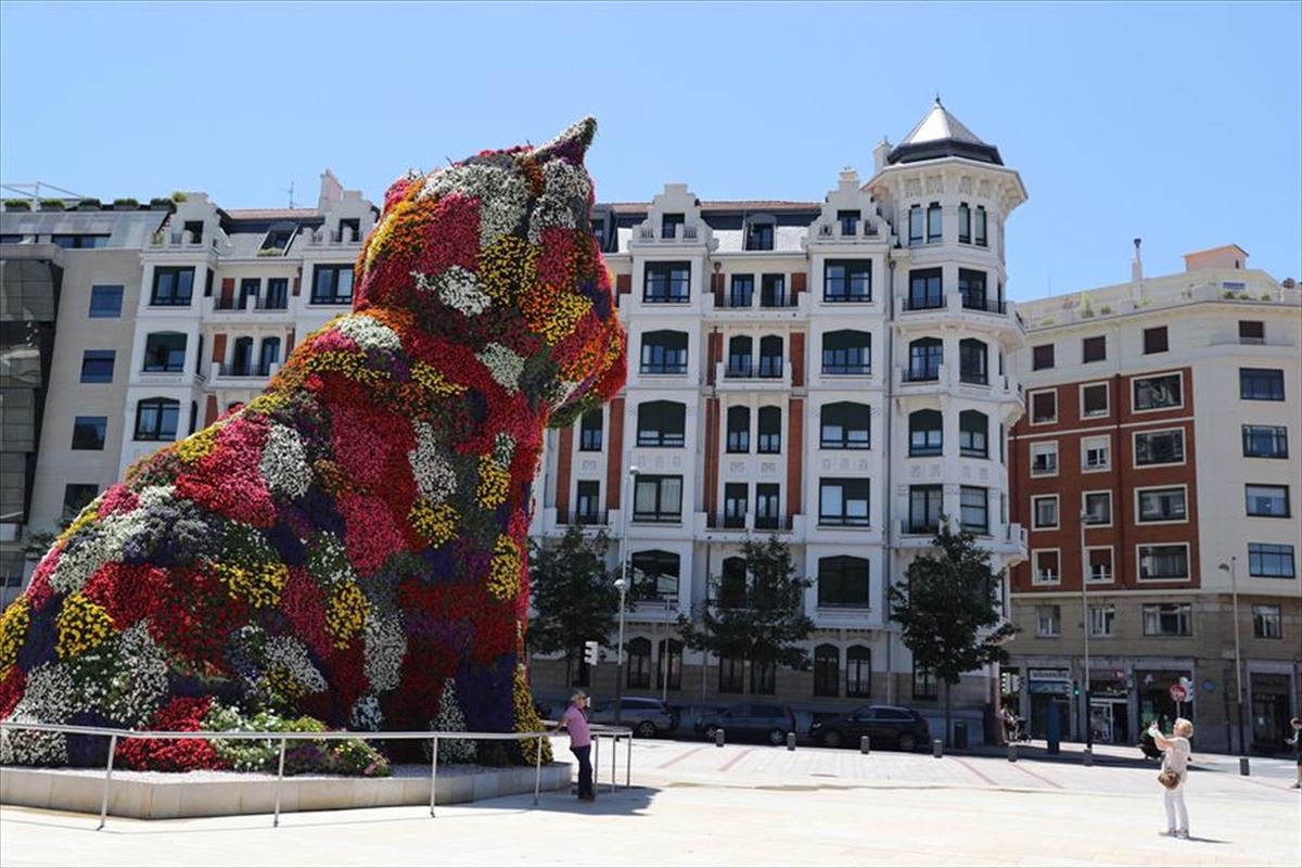 Turistas en la escultura Puppy el Guggenheim de Bilbao. Irudia: EFE.