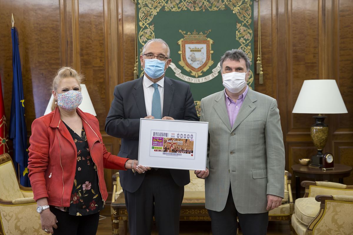 Pilar Herrero, Enrique Maya y Valentín Fortún con el diseño del cupón.