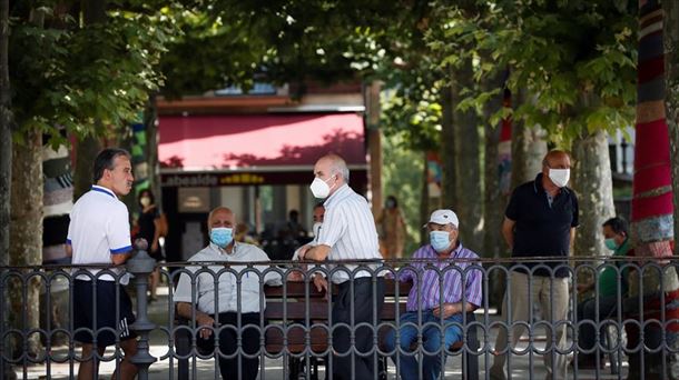 Varias personas con mascarilla en la calle.