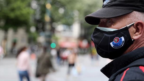 Un ertzaina con doble mascarilla en la Gran Vía de Bilbao