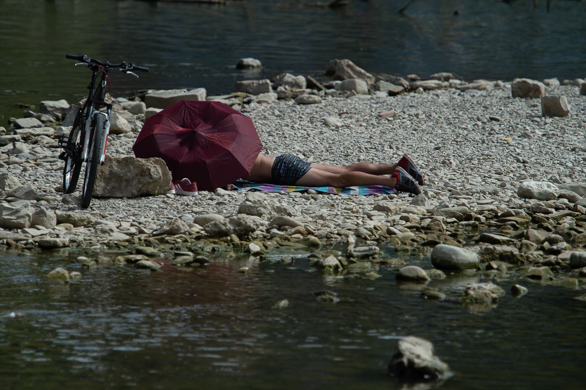 Una persona en la ribera de un río en Pamplona. 