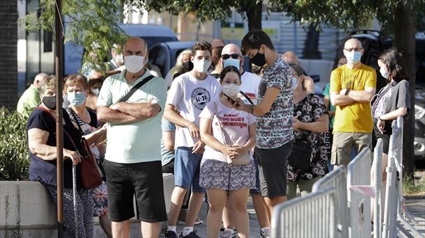 Varias personas esperan a un cribado. 