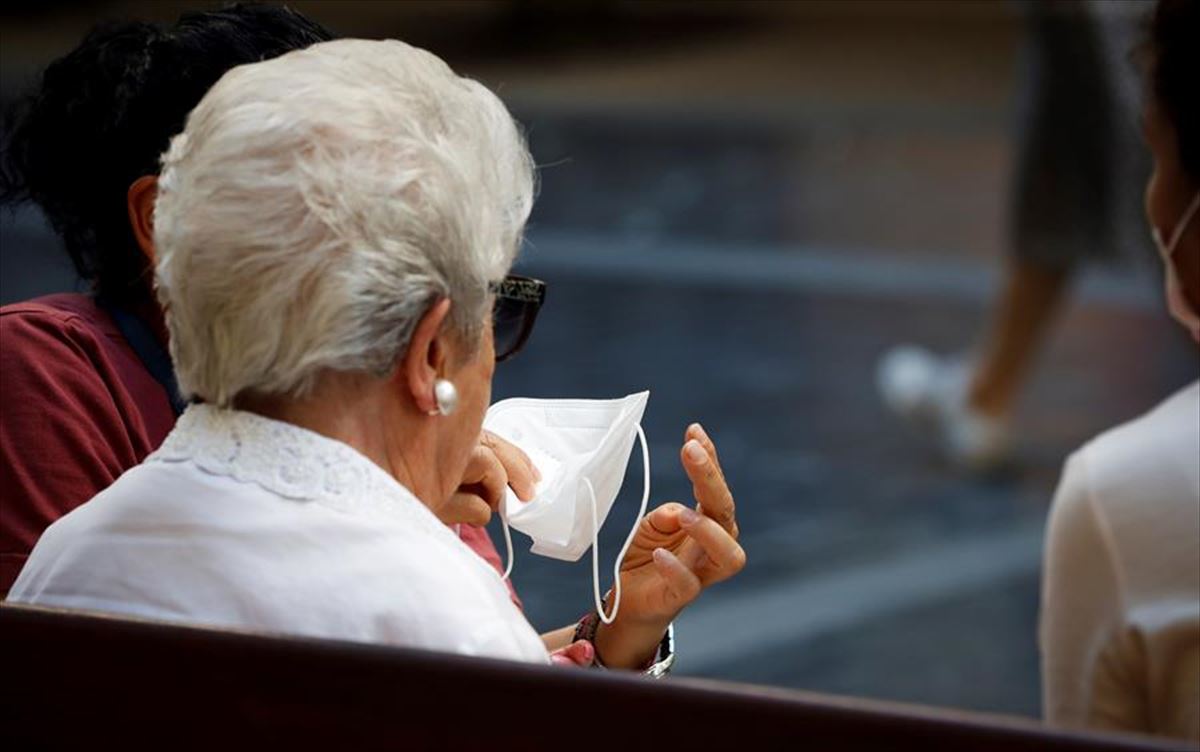 Una persona mayor se quita la mascarilla. Foto: Efe