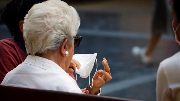 Una persona mayor se quita la mascarilla. Foto: Efe