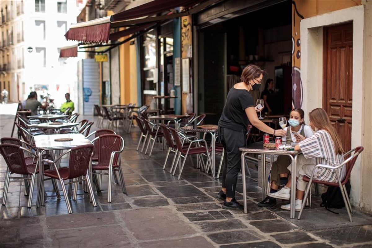 Una camarera atiende una mesa de una terraza. Foto de archivo: EFE