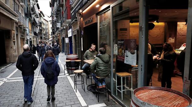 Varias personas pasean por una calle de Pamplona.