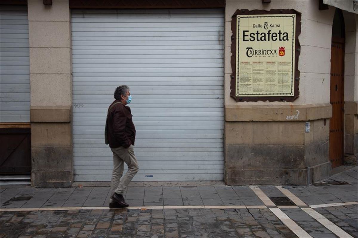 Un hombre pasa frente a un bar de Pamplona. 