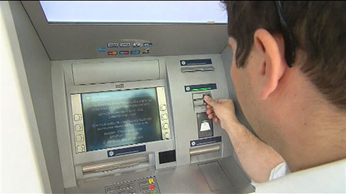 Un hombre saca dinero en un cajero automático. Foto: EFE