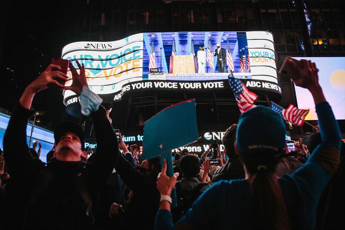 Ciudadanos demócratas siguen el discurso de Biden desde Times Square, en Nueva York.