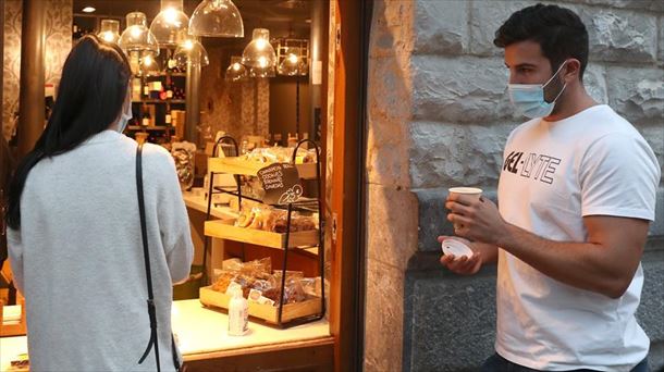 Clientes de un bar recogen café para llevar. Foto: Efe