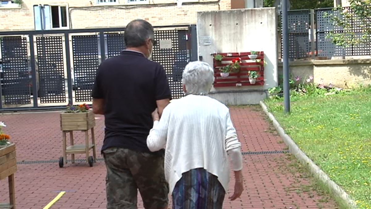 Un hombre visita a una persona mayor en una residencia de mayores.