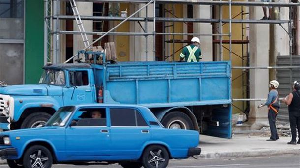 Unos hombres trabajan en la fachada de un edificio en La Habana (Cuba). Foto: EFE