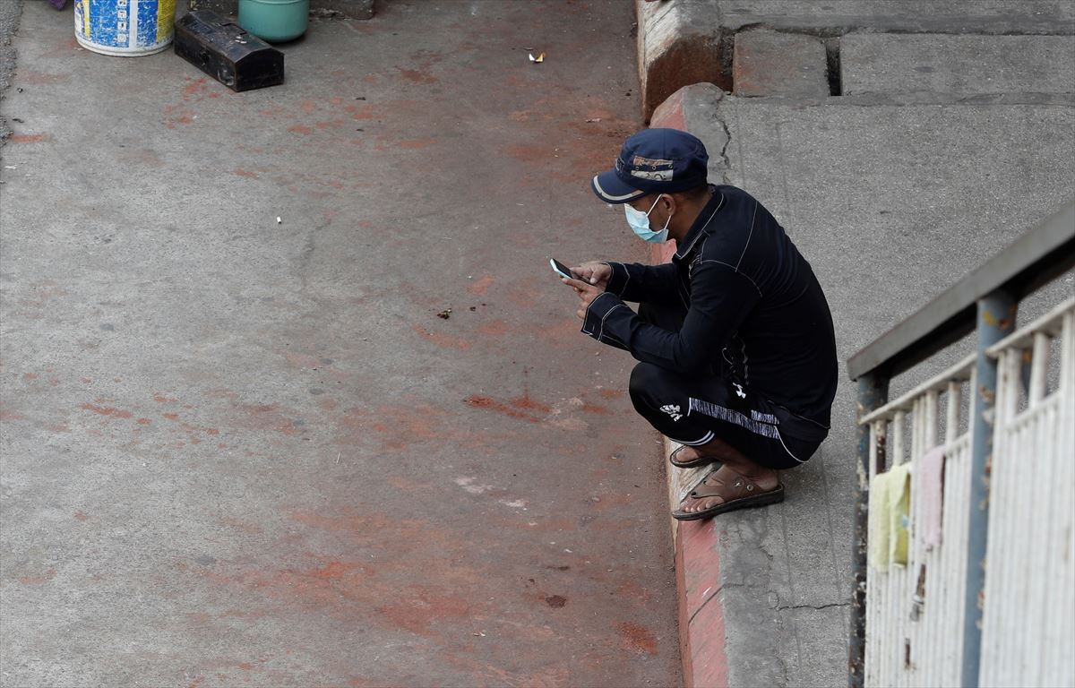 Hombre consulta un teléfono en las calles de Myanmar