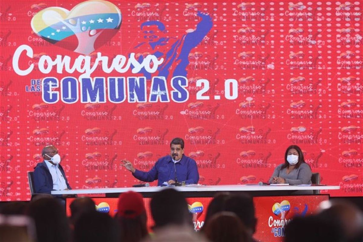 Maduro hablando en el congreso de las comunas junto a dos miembros de su partido.