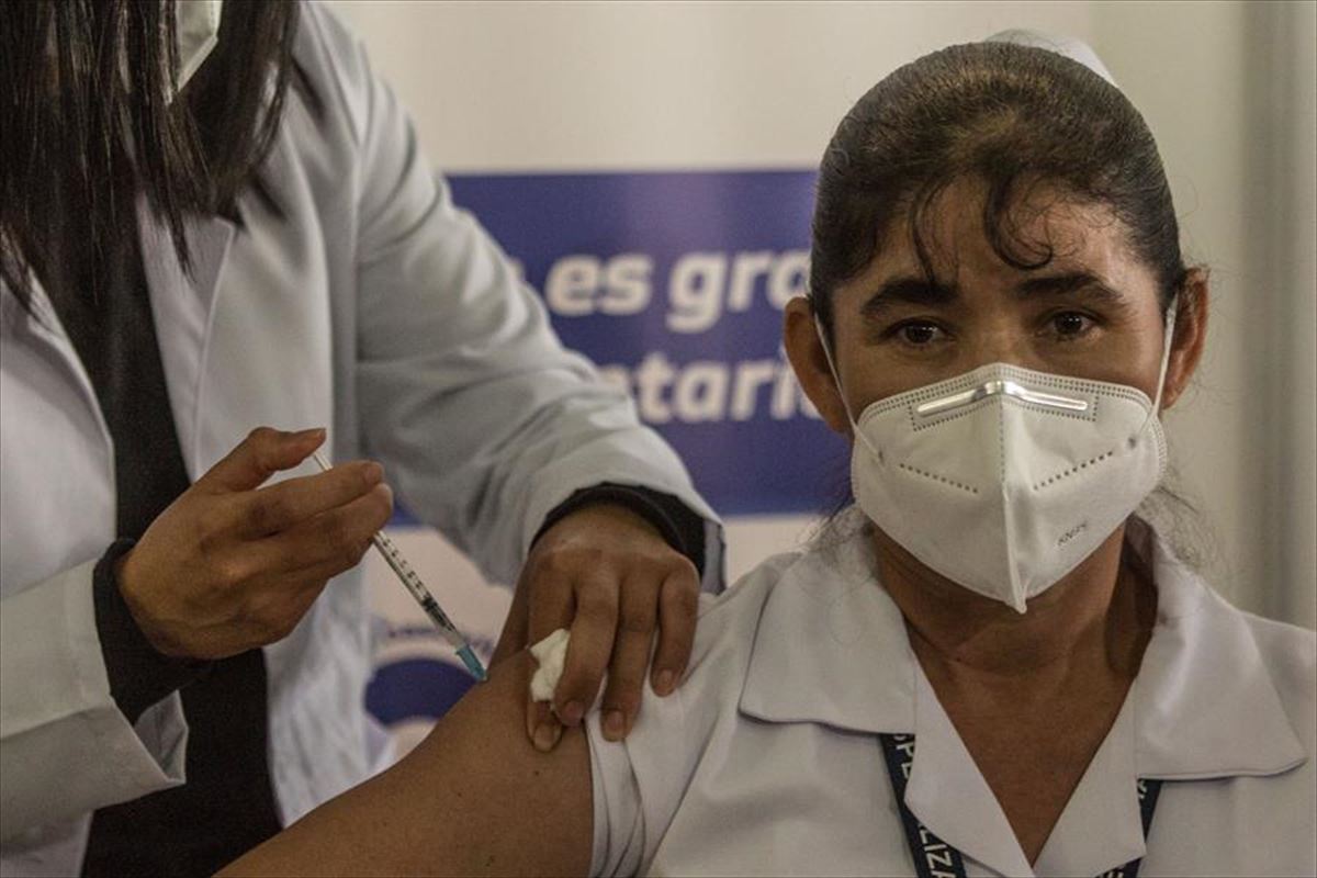 Una enfermera recibe la primera vacuna en Guatemala.