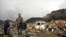 Familia rodeada de escombros causados por el terremoto. title=