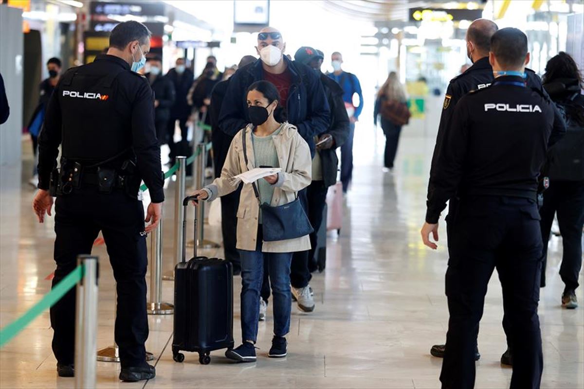 Una viajera muestra la documentación a un policía en el aeropuerto de Barajas.
