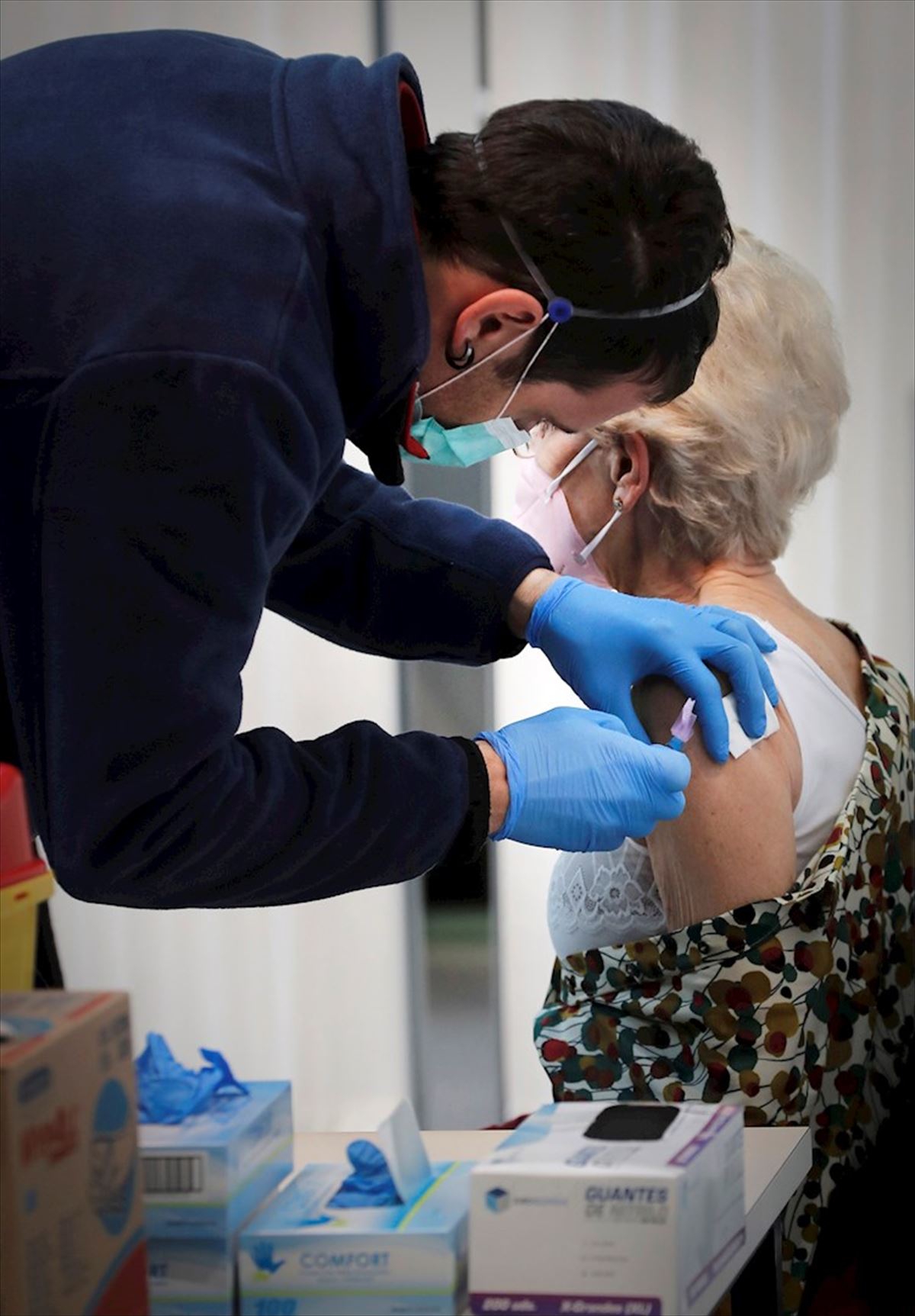 Personal sanitario administrando la vacuna contra el coronavirus a una mujer