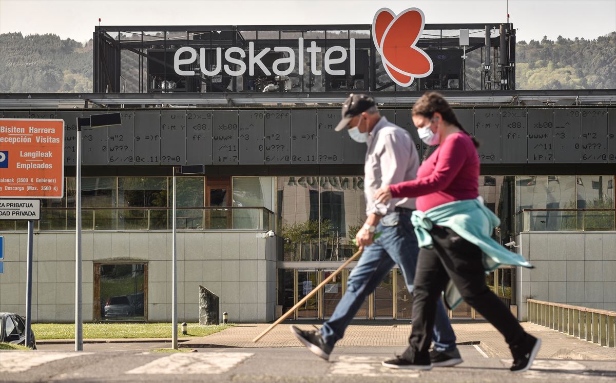 Dos personas pasean ante la sede de Euskaltel. Foto: EFE