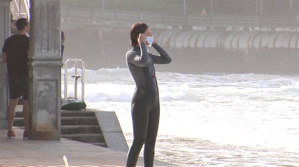 Una persona con mascarilla frente al mar