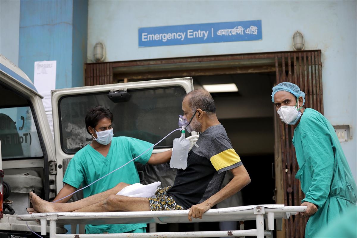 Sanitarios indios trasladan a un paciente covid