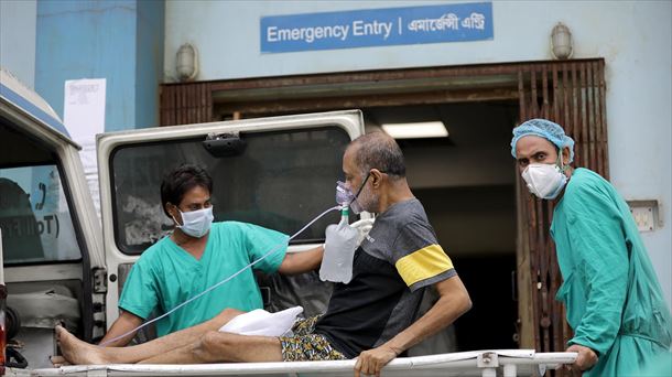 Dos sanitarios trasladan a un paciente covid